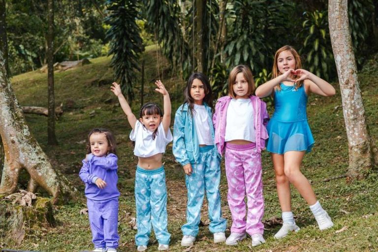 Grupo de niñas de diferentes edades con conjuntos deportivos y casuales en un entorno natural.