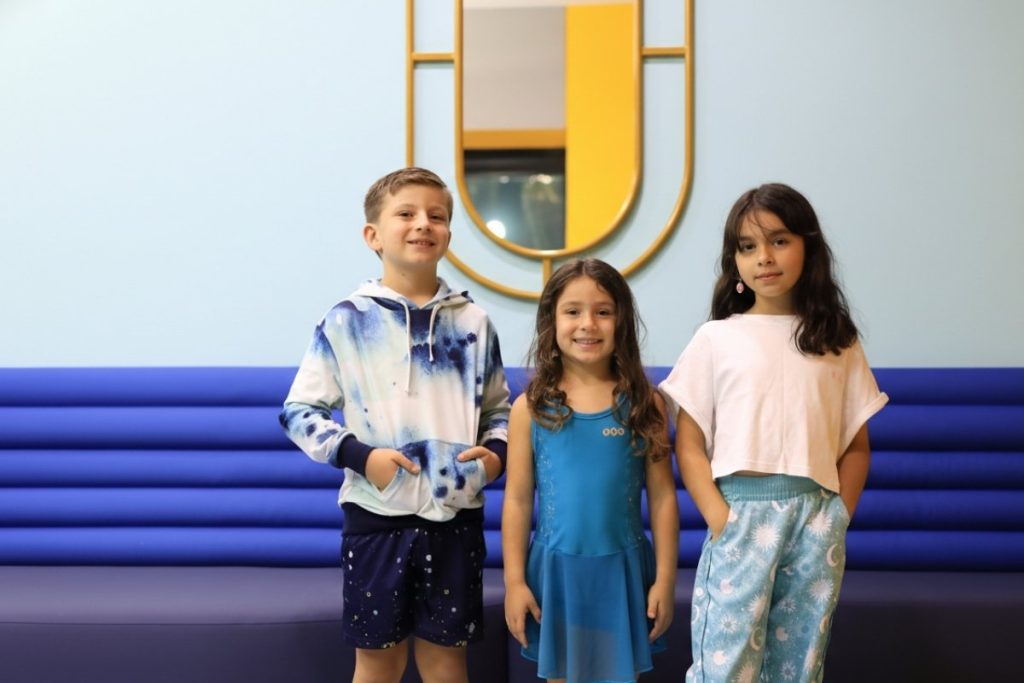 Grupo de niños con outfits infantiles modernos y cómodos, incluyendo sudaderas tie-dye y vestidos deportivos