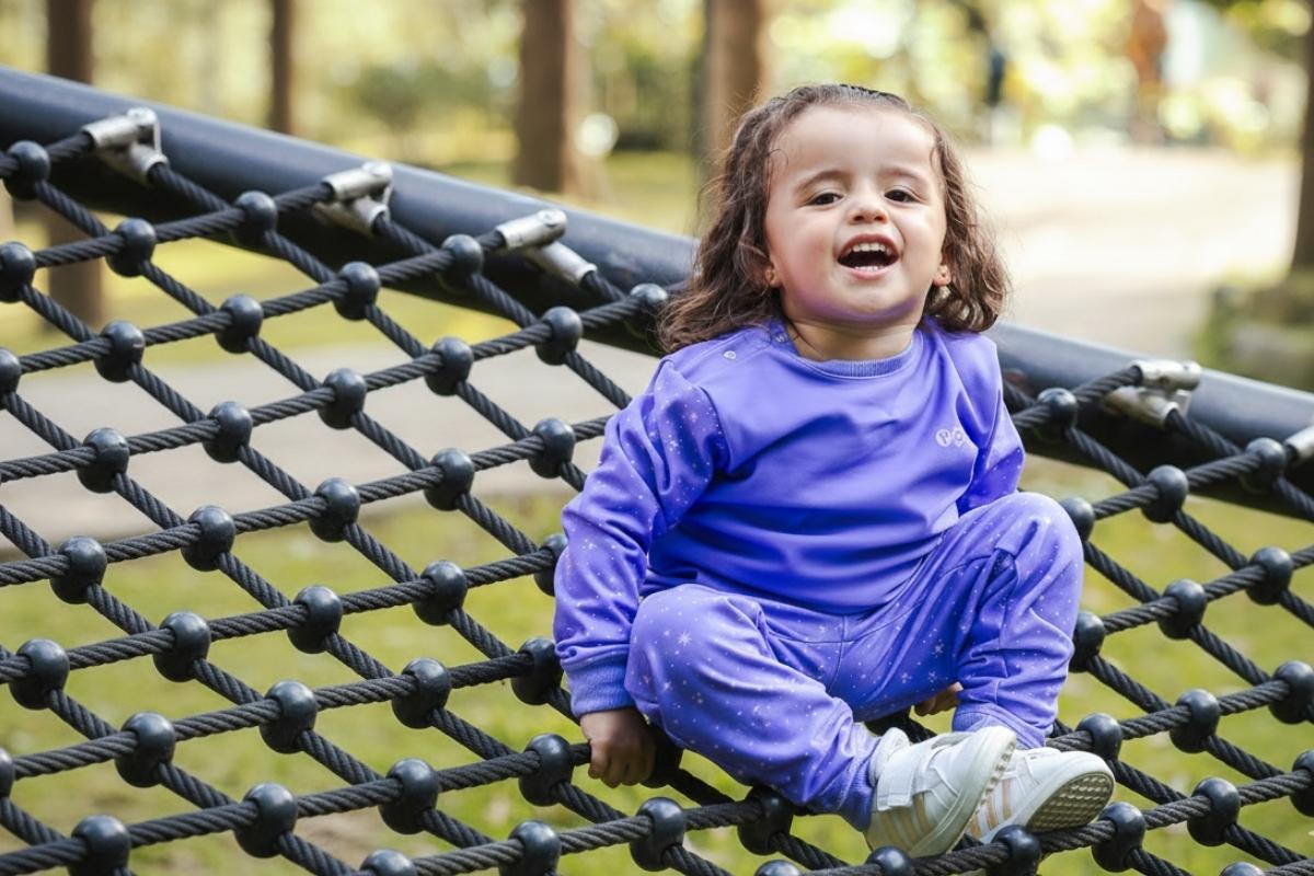 Niñas explorando la naturaleza con ropa resistente en tonos violeta y azul turquesa.