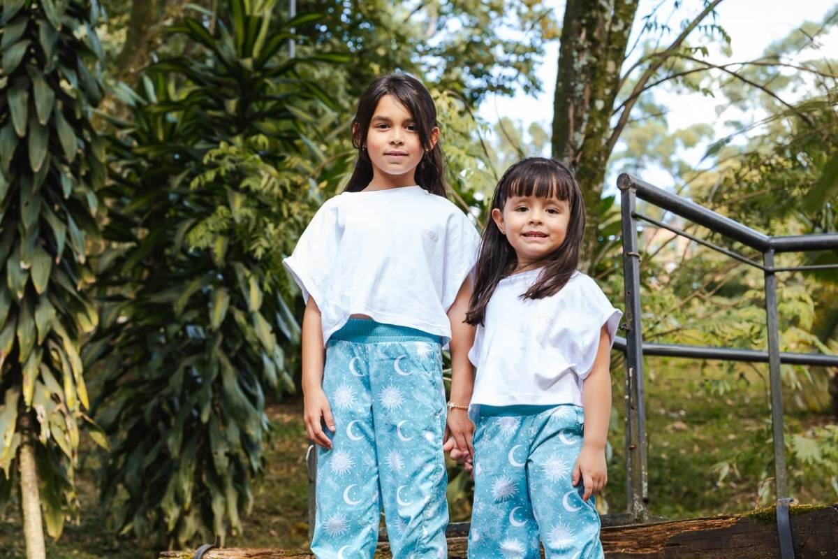 Niñas de diferentes edades luciendo el mismo modelo de pantalón azul con estampado galáctico